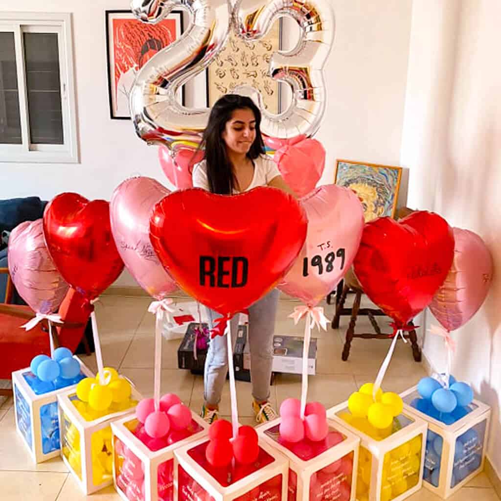 בלונים עבור מעריצה של טיילור סוויפט עם כל שמות האלבומים והשירים של הזמרת מודפסים על מארזי ברכות עם בלונים בצורת לב והספרות 23